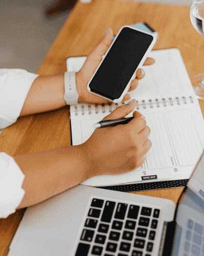 Imagem de uma pessoa segurando o smartphone ao lado de um notebook - Barick