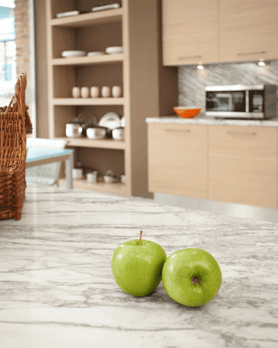 Imagem de uma cozinha, uma mesa com duas maçãs verde