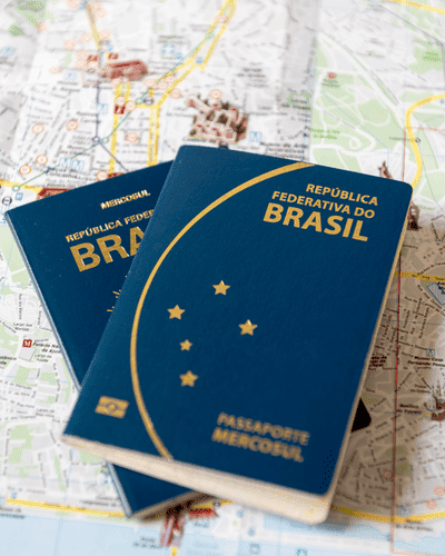 Imagem de dois passaportes brasileiros sobre um mapa